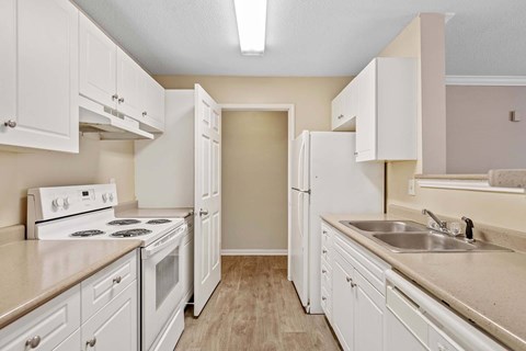 A kitchen with white cabinets and appliances.