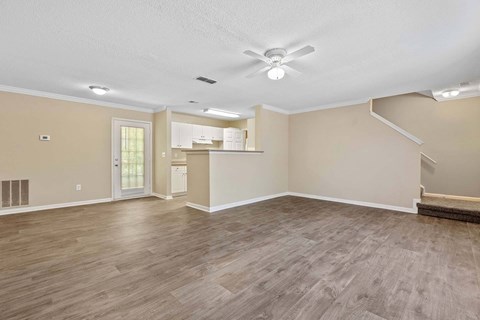 A spacious room with a ceiling fan and lighting fixtures.