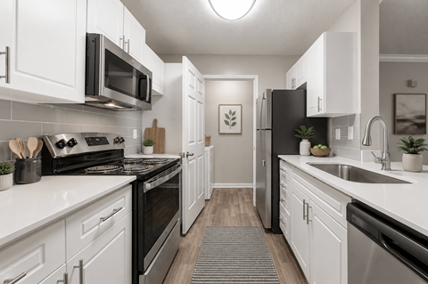 A modern kitchen with black appliances and white cabinets.