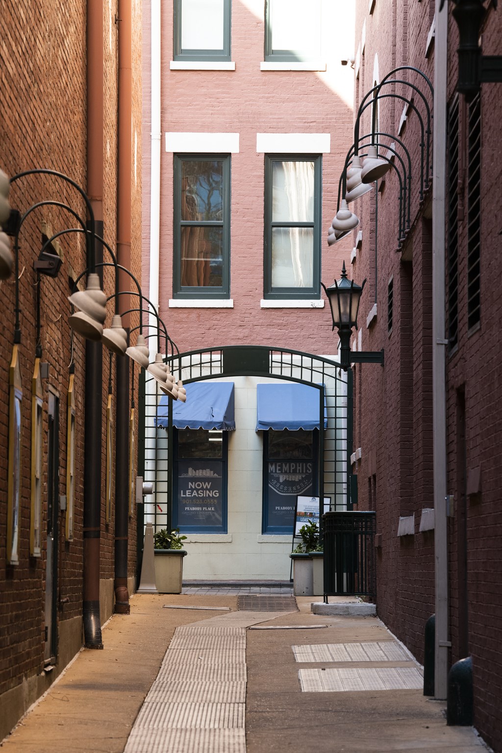 an empty alleyway with a brick building with a blue awning