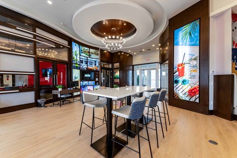A dining area with a table surrounded by chairs.