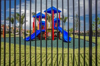 a playground is seen through a fence