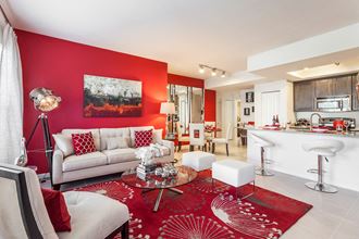a living room with a red accent wall and white furniture at Altis Kendall Square, Miami, FL