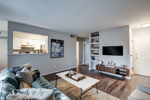 A living room with a blue couch and a white coffee table.