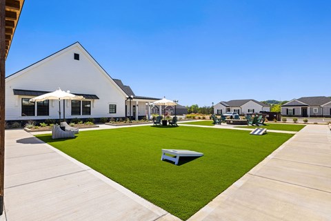 A white building with a green lawn in front.
