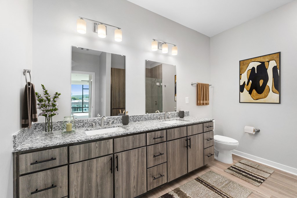 A bathroom with a large mirror, a sink, and a toilet.