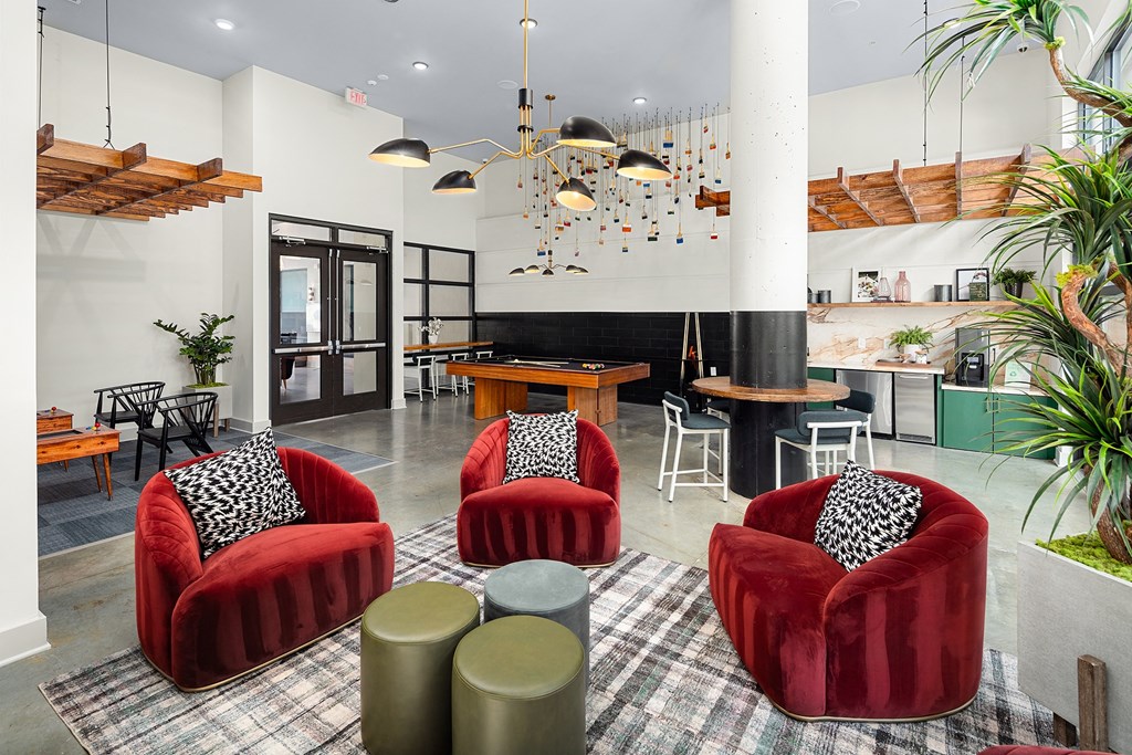 a living room with red chairs and a table