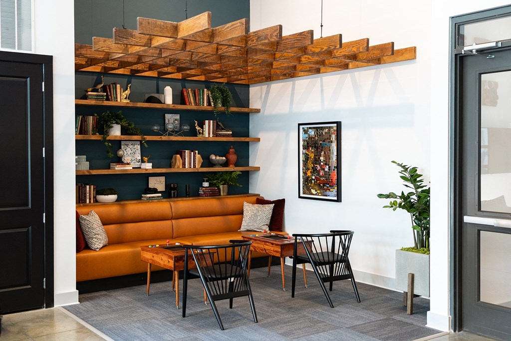 a living room with a brown couch and a table and chairs