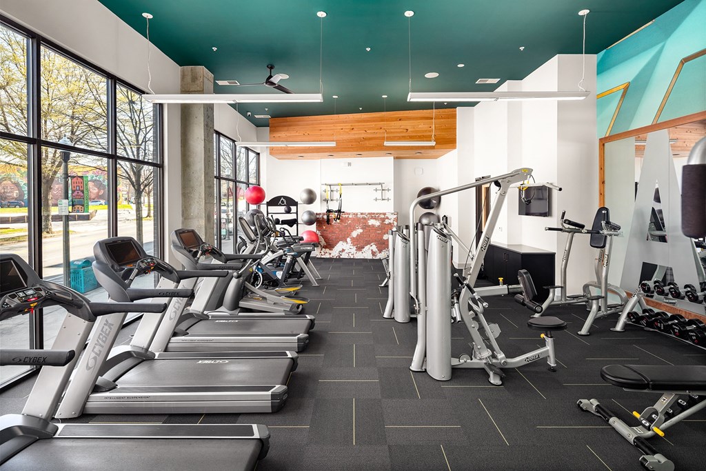 a gym filled with cardio equipment and weights
