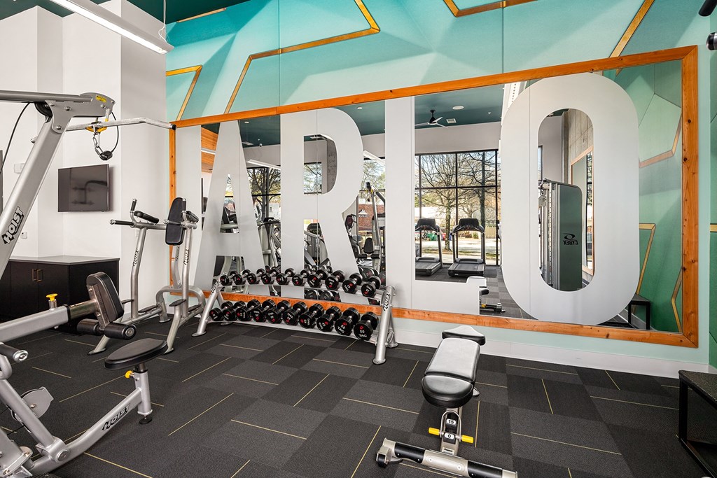 a gym with weights and cardio machines and a large sign with the word rehab on