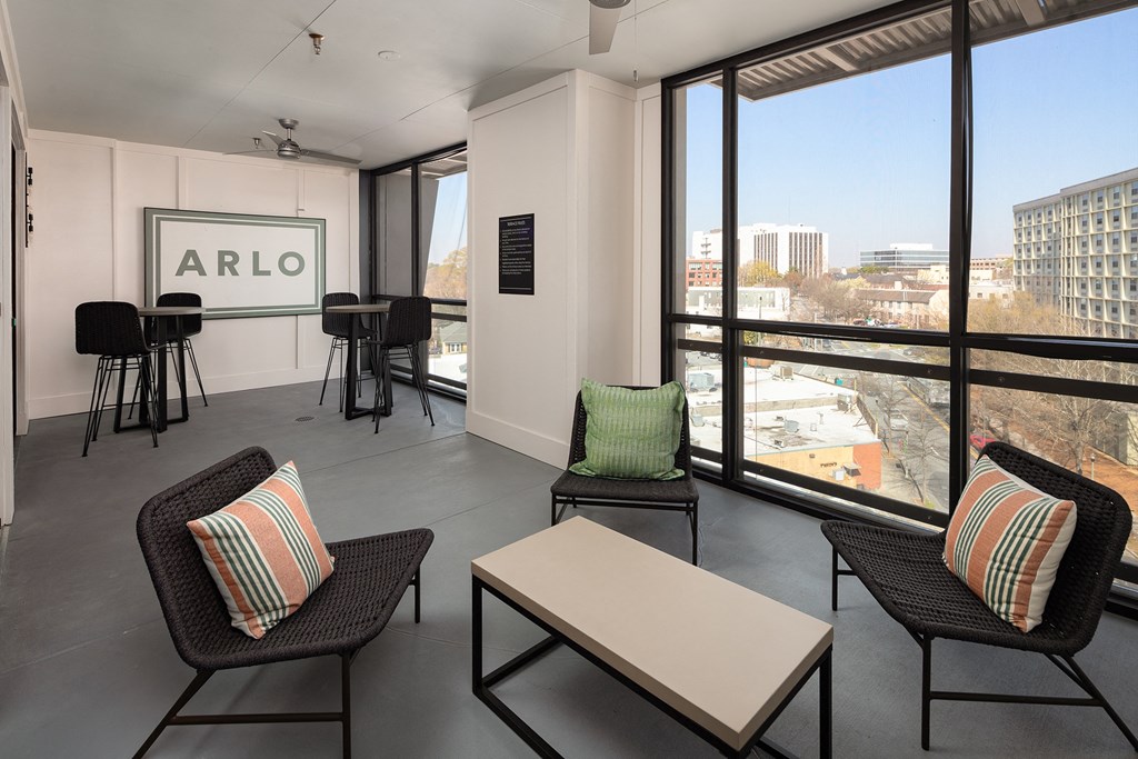 a living room with chairs and a table and a view of the city