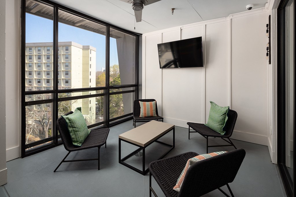 a living room with chairs and a table and a television