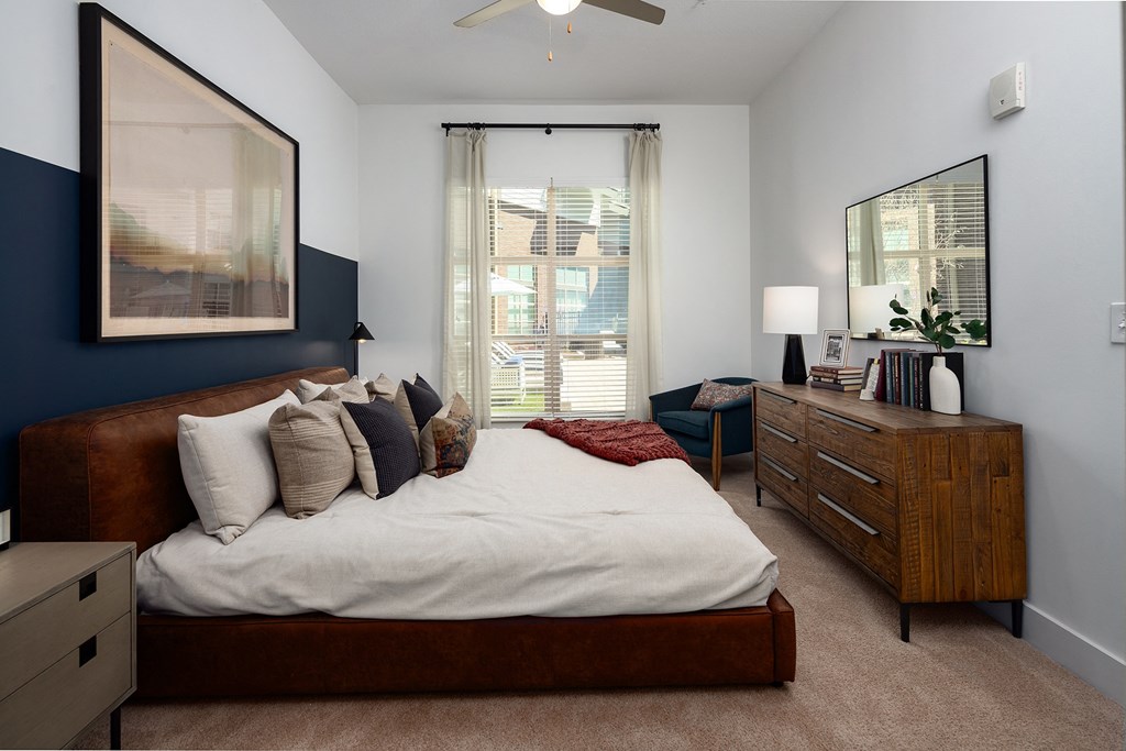 a bedroom with a bed and a dresser and a window