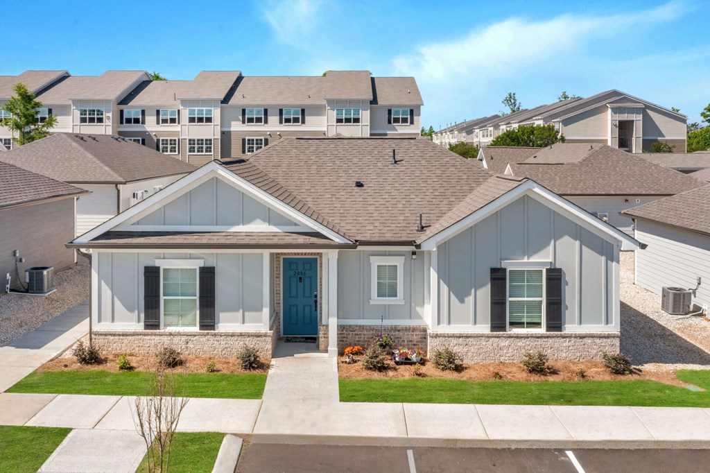 a house with a blue door on a street with other houses