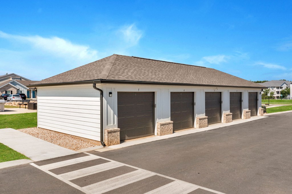 a garage with three roll up garage doors on the side of a house