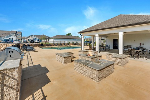 the clubhouse has a patio with a fire pit and a pool