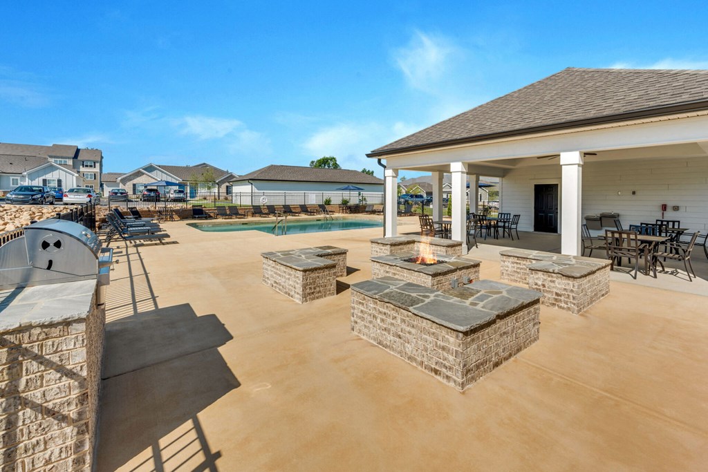 the clubhouse has a patio with a fire pit and a pool