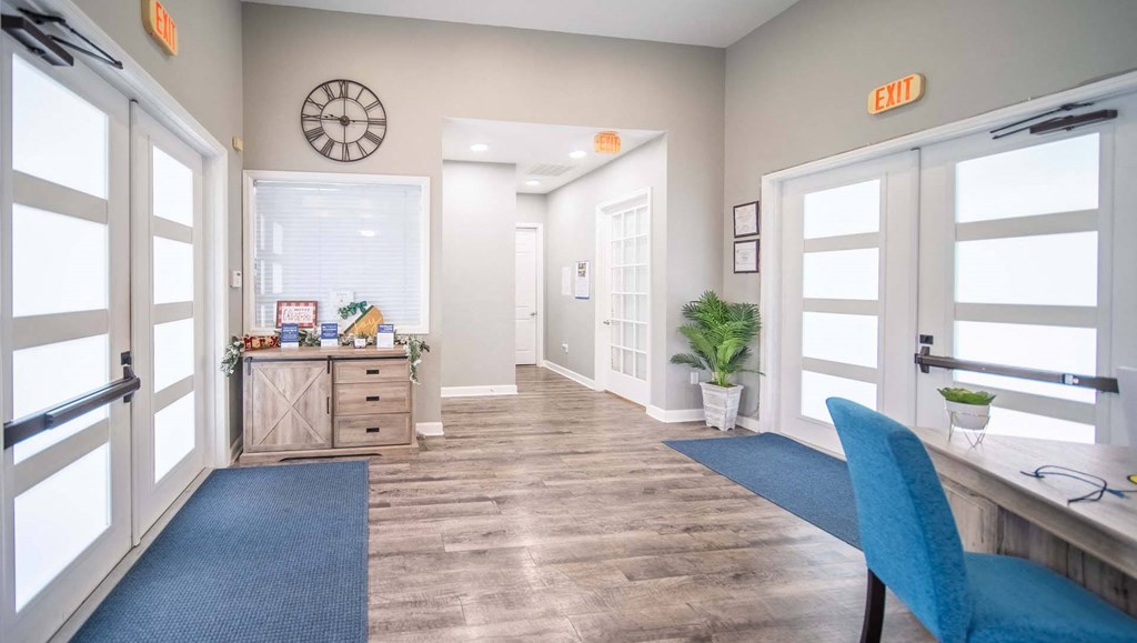 A blue chair is in front of a desk with a computer on it.