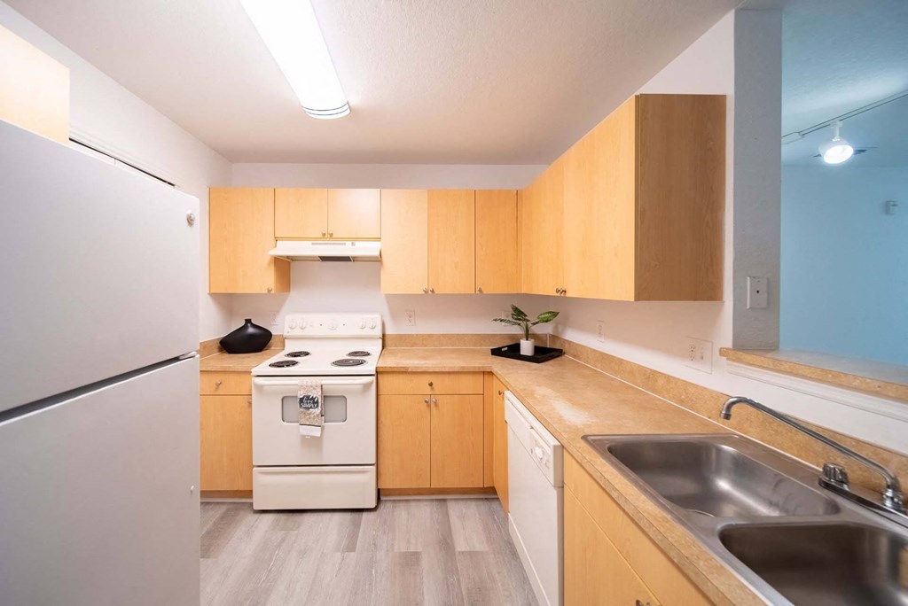 A kitchen with wooden cabinets and a white refrigerator.