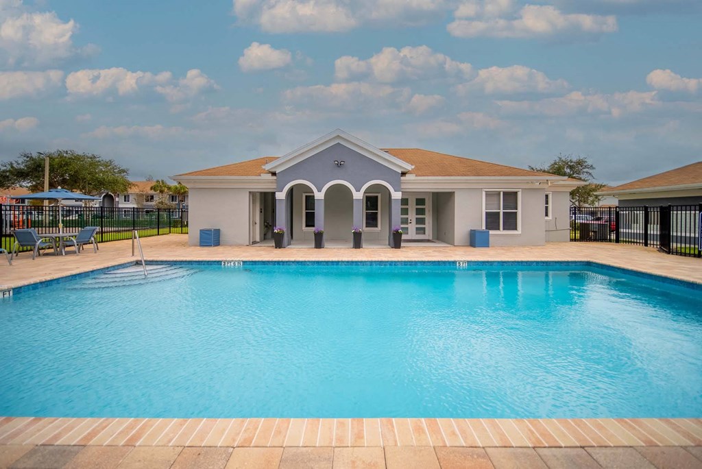 A swimming pool in front of a house.