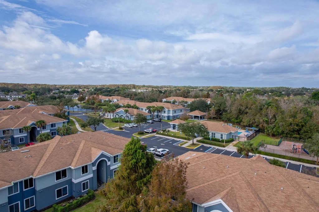 A view of a residential area with houses and a parking lot.