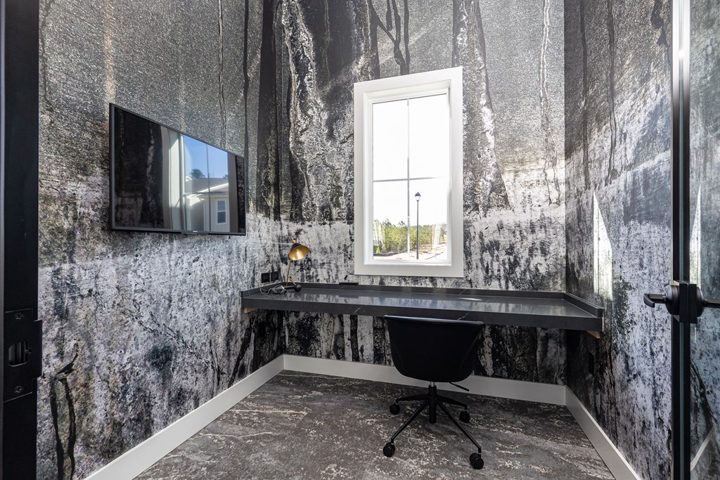 a home office with a desk and a window