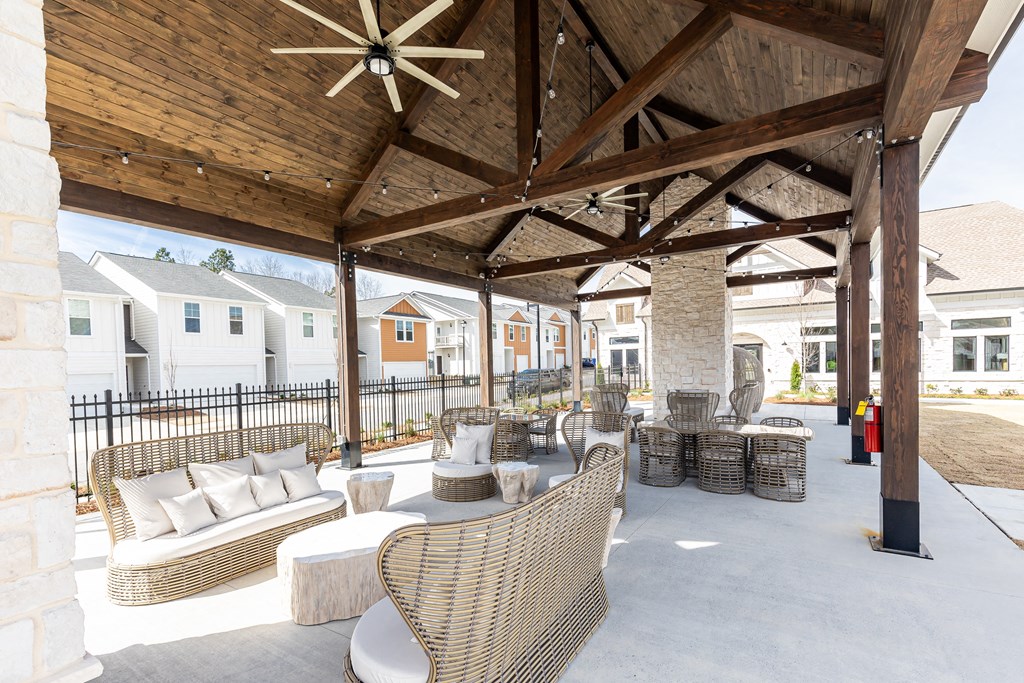 a covered patio with wicker chairs and tables
