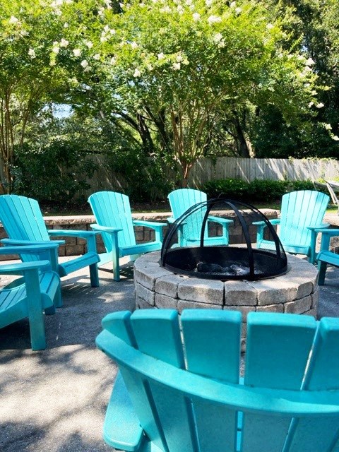 a group of blue chairs sitting around a fire pit