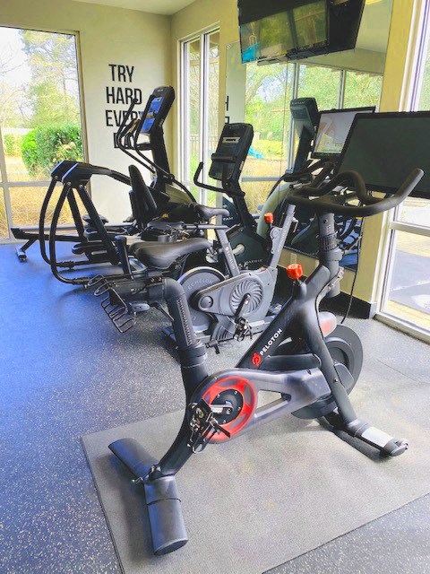 a gym with a row of exercise bikes on the floor