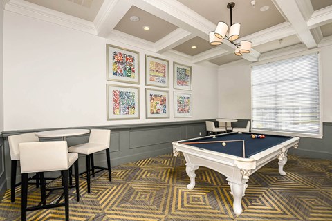 a games room with a pool table and chairs