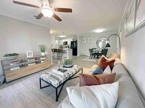 A living room with a striped couch and a ceiling fan.