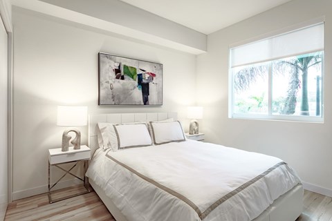 A bedroom with a large bed and a painting on the wall.
