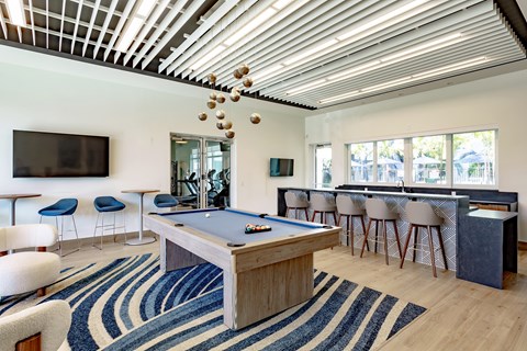 A room with a pool table and a television.