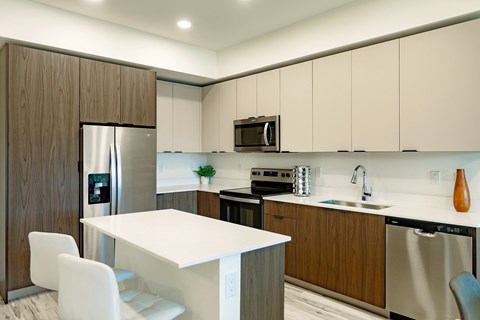A modern kitchen with a white table and chairs.