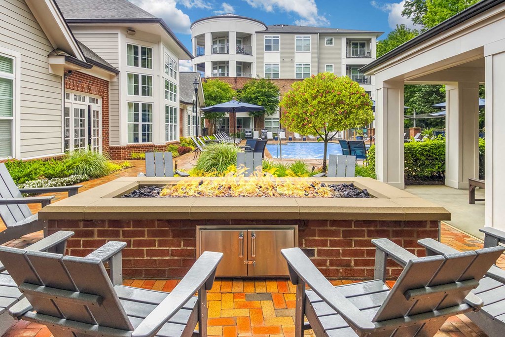 A backyard with a fire pit and chairs.