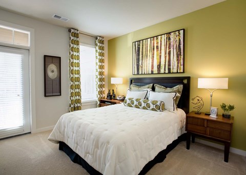A bedroom with a large bed and a painting on the wall.