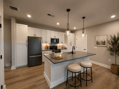 A kitchen with a black refrigerator and white cabinets.