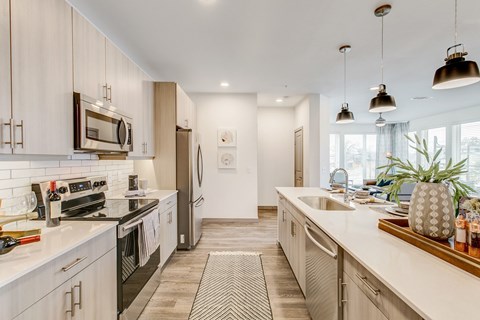 A modern kitchen with white cabinets and stainless steel appliances.