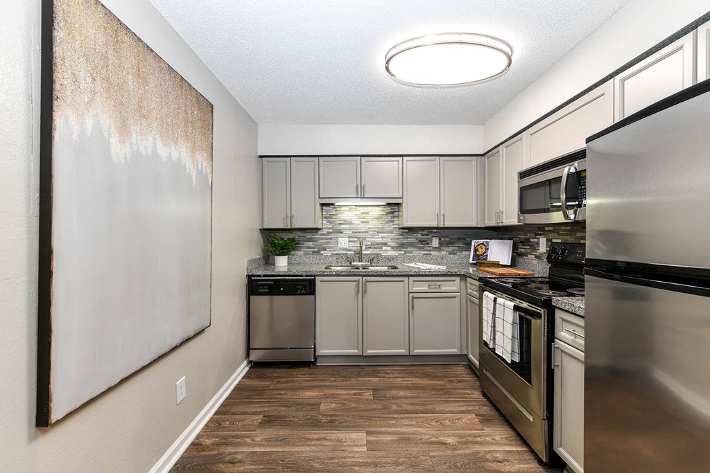 a kitchen with stainless steel appliances and a wooden floor  at District at Vinings, Atlanta