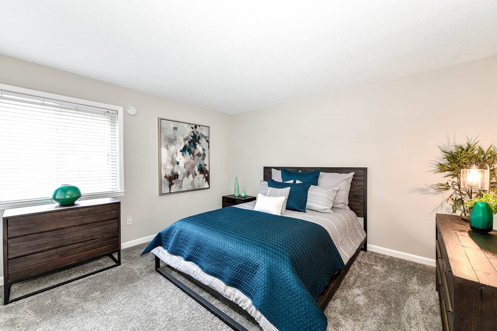 a bedroom with a bed and dresser  at District at Vinings, Atlanta, GA