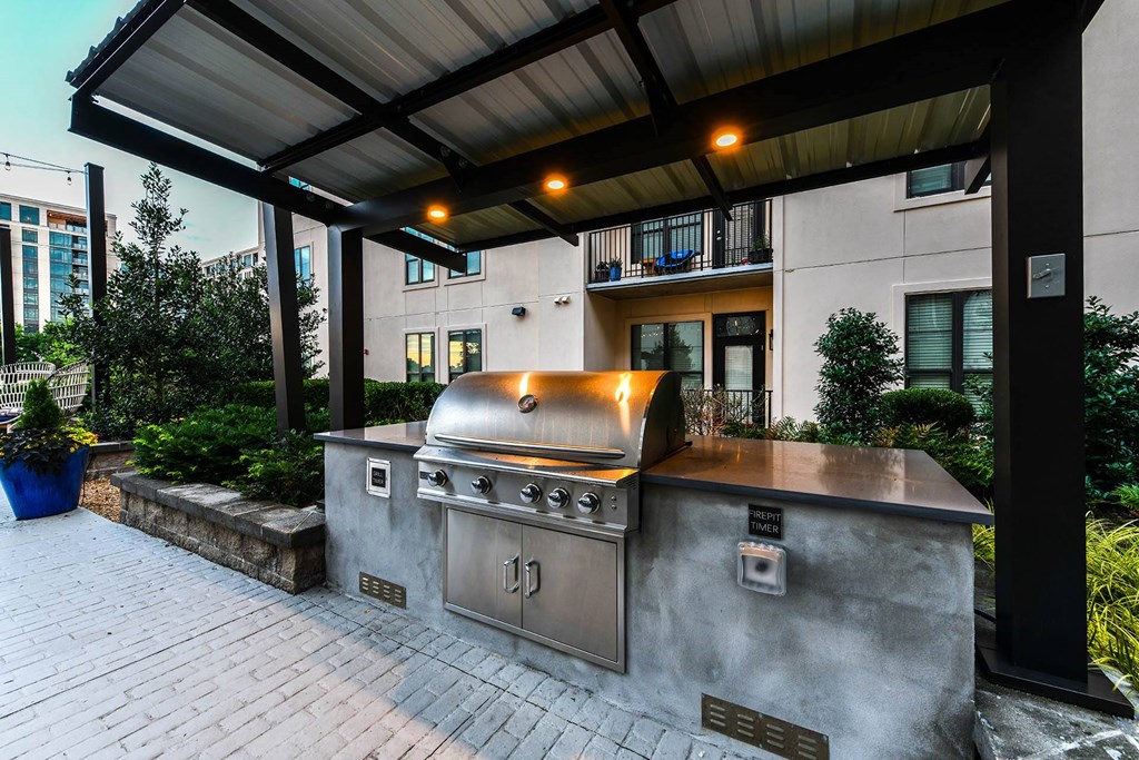a large outdoor kitchen with stainless steel appliances and a pergola