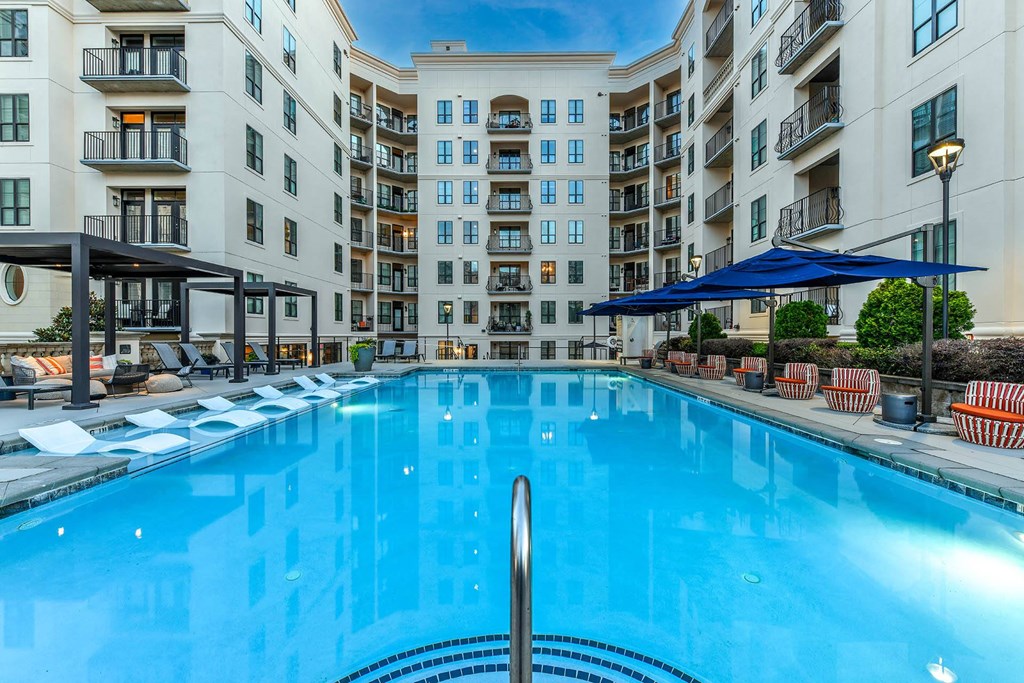 a large swimming pool in front of an apartment building