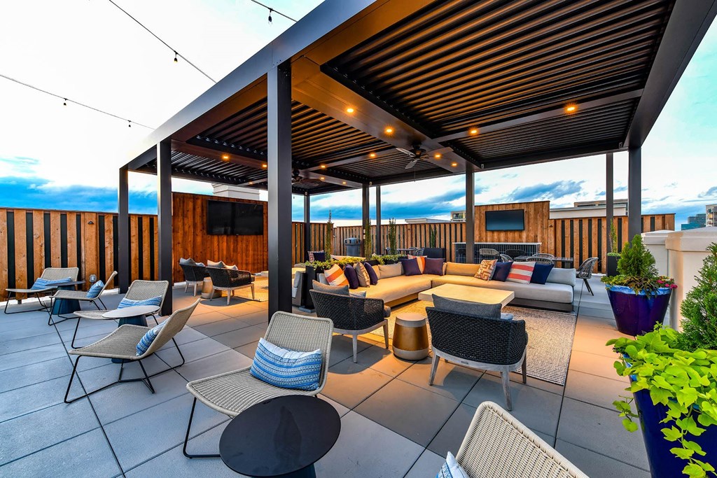 a roof top patio with a couch and chairs