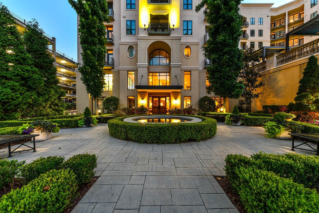 a courtyard with a fountain in front of a building