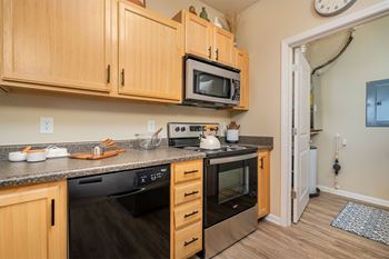 A kitchen with wooden cabinets and a black stove top oven.