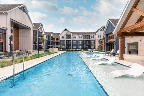 Pooler, GA, Apartments for Rent - Miro - Resort Style Pool With In Water Lounge Chairs, Covered Outdoor Seating, Timber Beams, And Surrounding Apartment Buildings.