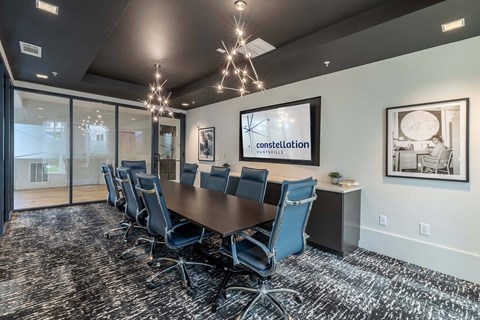 A conference room with a long table and chairs.