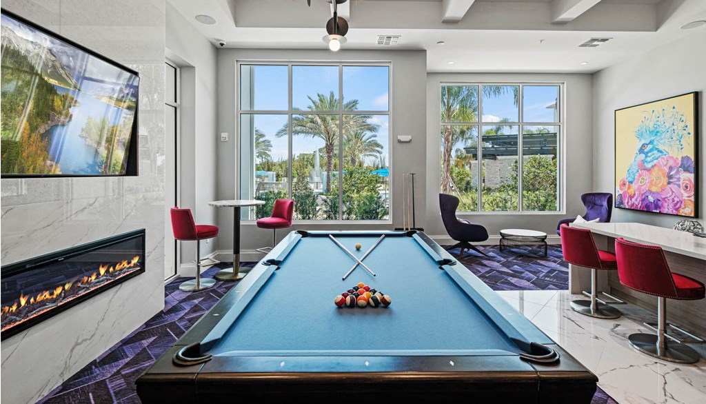 a game room with a pool table and a view of a fireplace