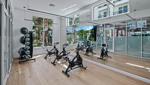 the home gym has a wall of windows and a wood floor at Altis Grand Lake Willis, Orlando, 32821