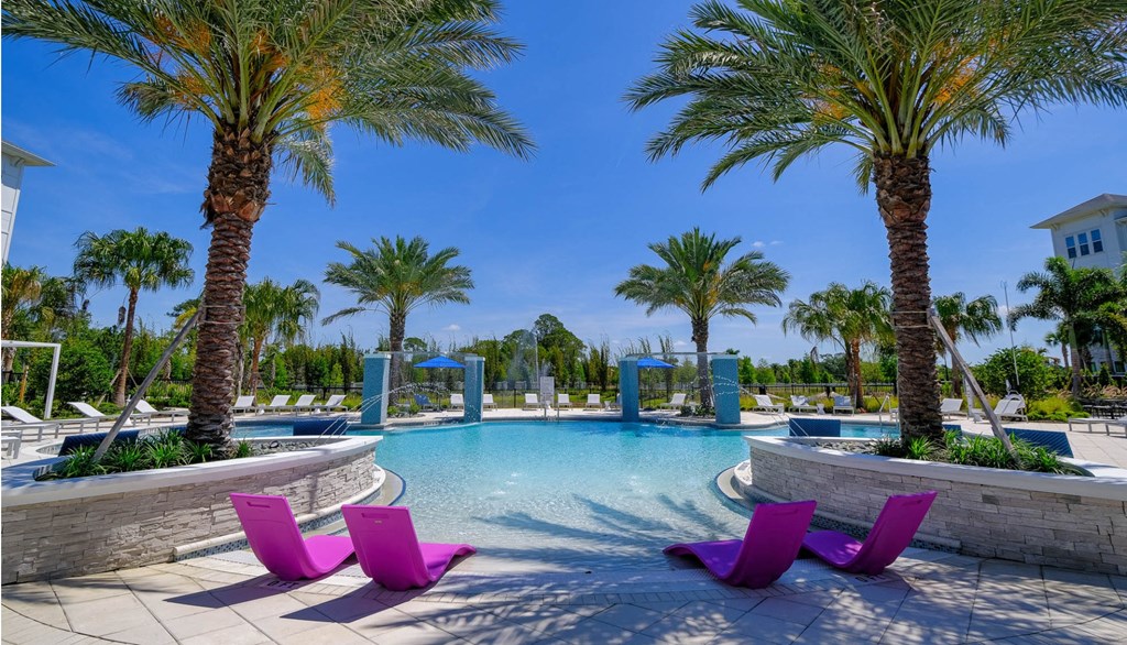 a large swimming pool with purple chairs and palm trees